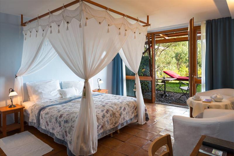 um quarto com uma cama de dossel e um pátio em Atrio em Estreito da Calheta