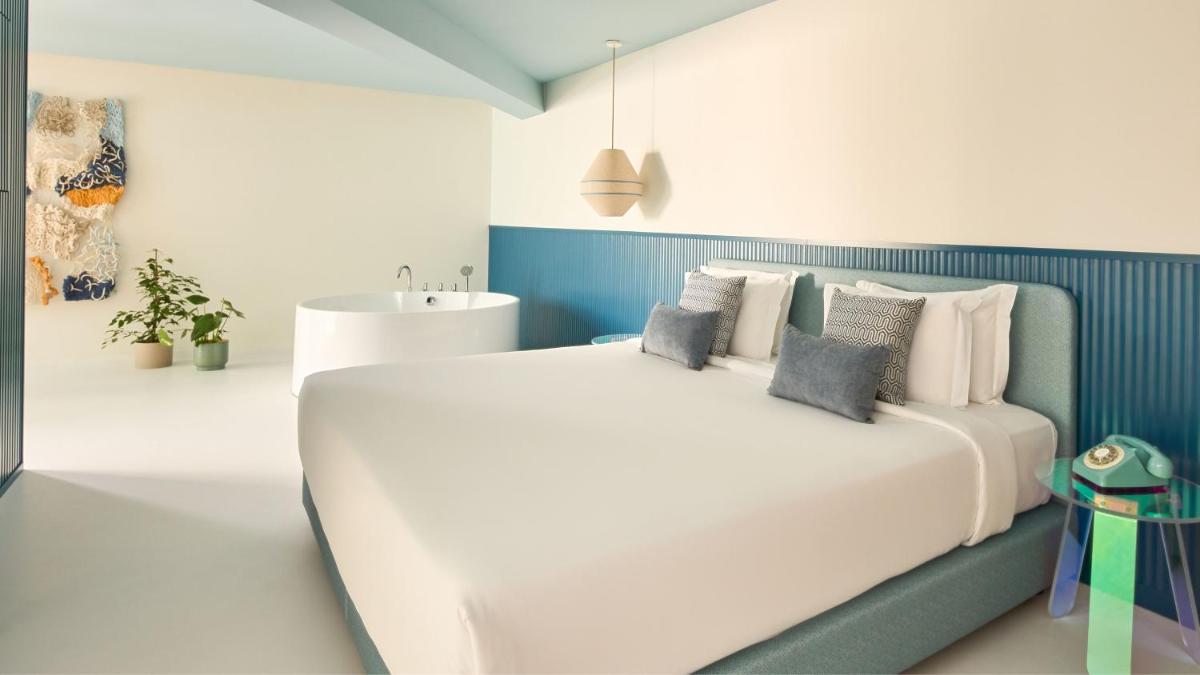 um quarto com uma cama grande e um lavatório em Hotel Indigo Albufeira by IHG em Albufeira