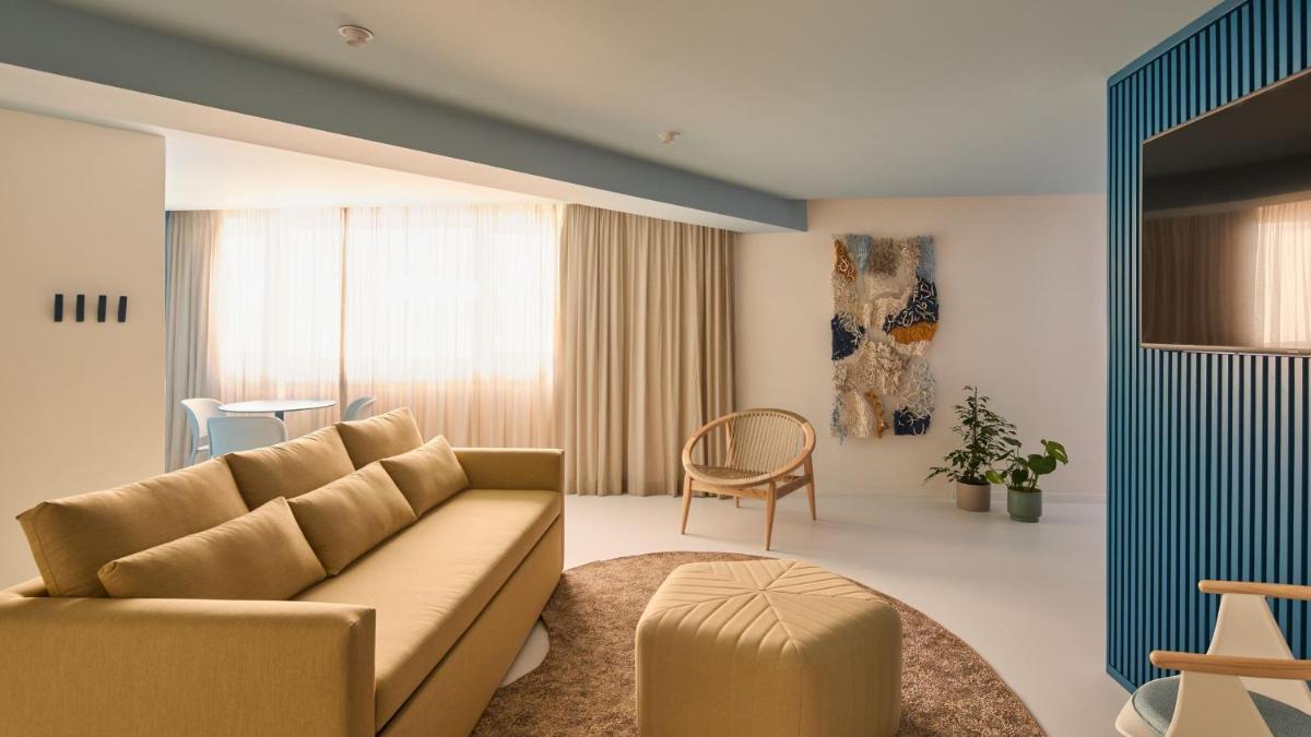 uma sala de estar com um sofá e uma cadeira em Hotel Indigo Albufeira by IHG em Albufeira