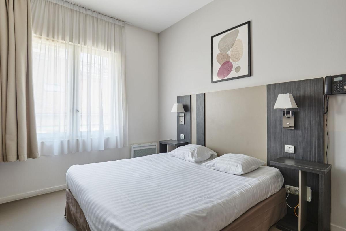 Un ou plusieurs lits dans un hébergement de l'établissement Appart'hôtel Odalys City - Dijon Centre Les Cordeliers