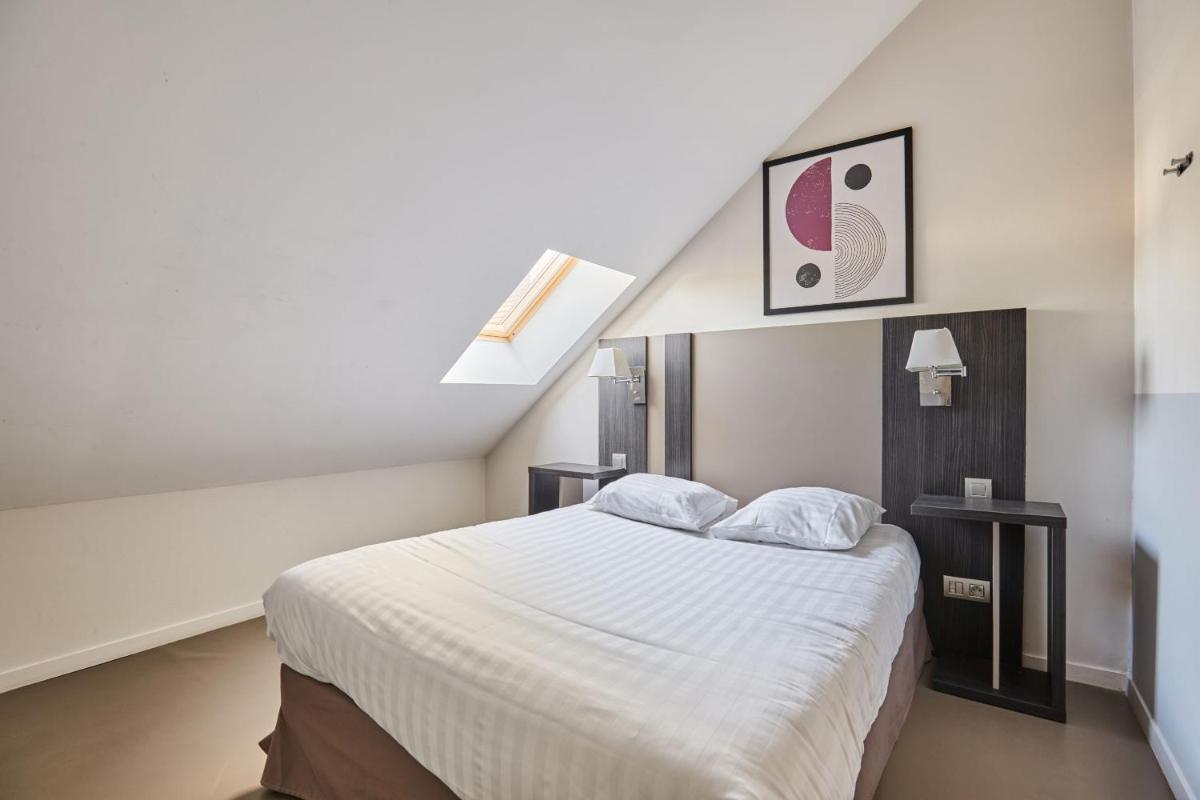 Un ou plusieurs lits dans un hébergement de l'établissement Appart'hôtel Odalys City - Dijon Centre Les Cordeliers