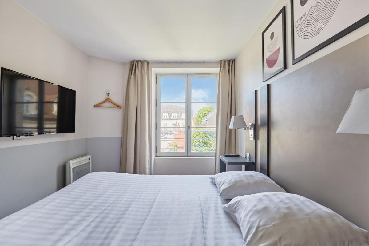Un ou plusieurs lits dans un hébergement de l'établissement Appart'hôtel Odalys City - Dijon Centre Les Cordeliers