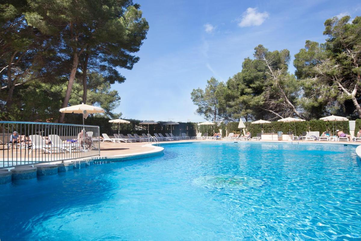 una gran piscina con sillas y sombrillas en Grupotel Orient, en Playa de Palma