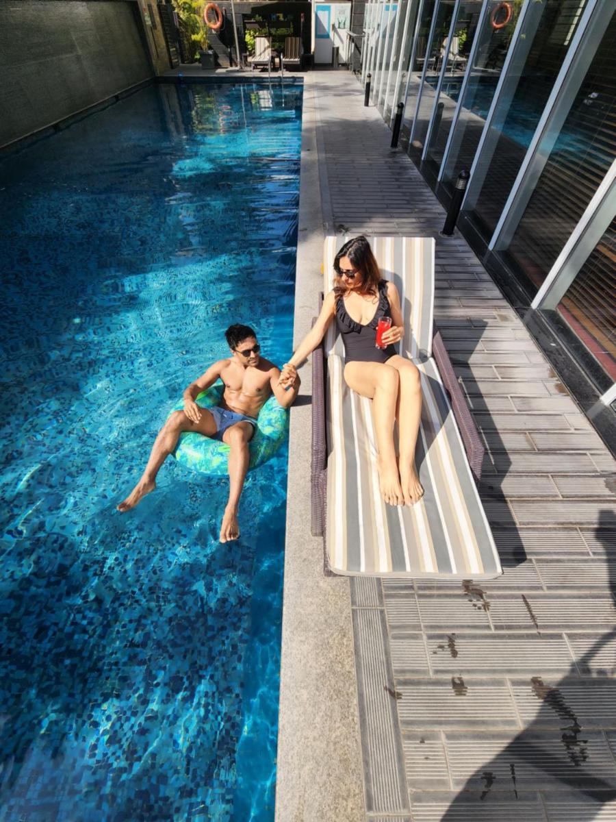 a man and a woman sitting in a swimming pool at Marriott Suites Pune in Pune