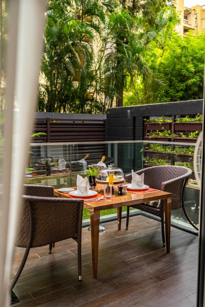 a wooden table and chairs on a patio with a view at Marriott Suites Pune in Pune
