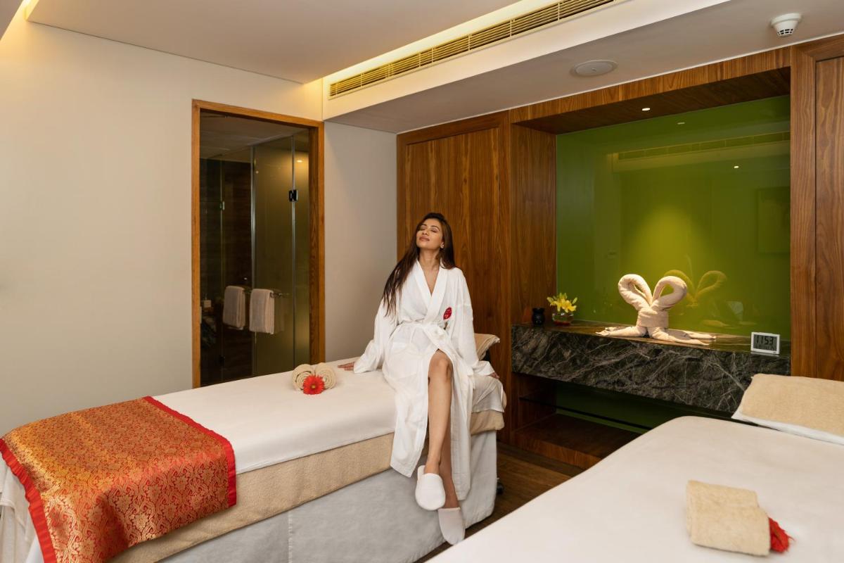 a woman sitting on a bed in a hotel room at Marriott Suites Pune in Pune
