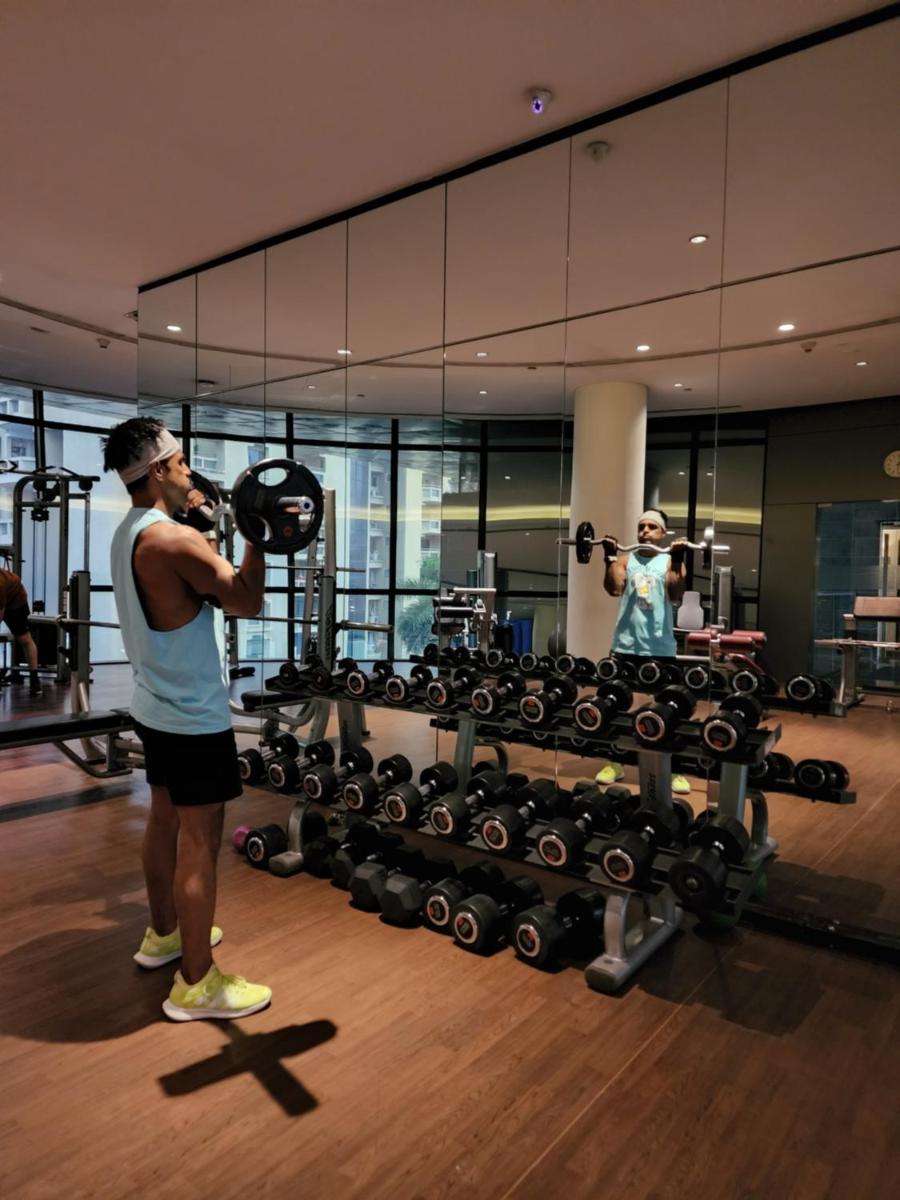 a man standing in front of a gym with a machine at Marriott Suites Pune in Pune