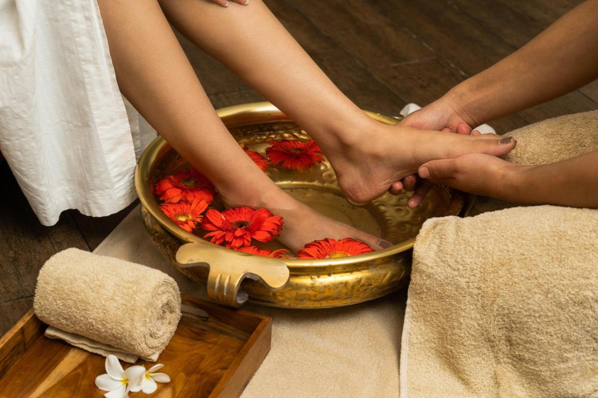 two people holding their feet in a bowl of flowers at Marriott Suites Pune in Pune
