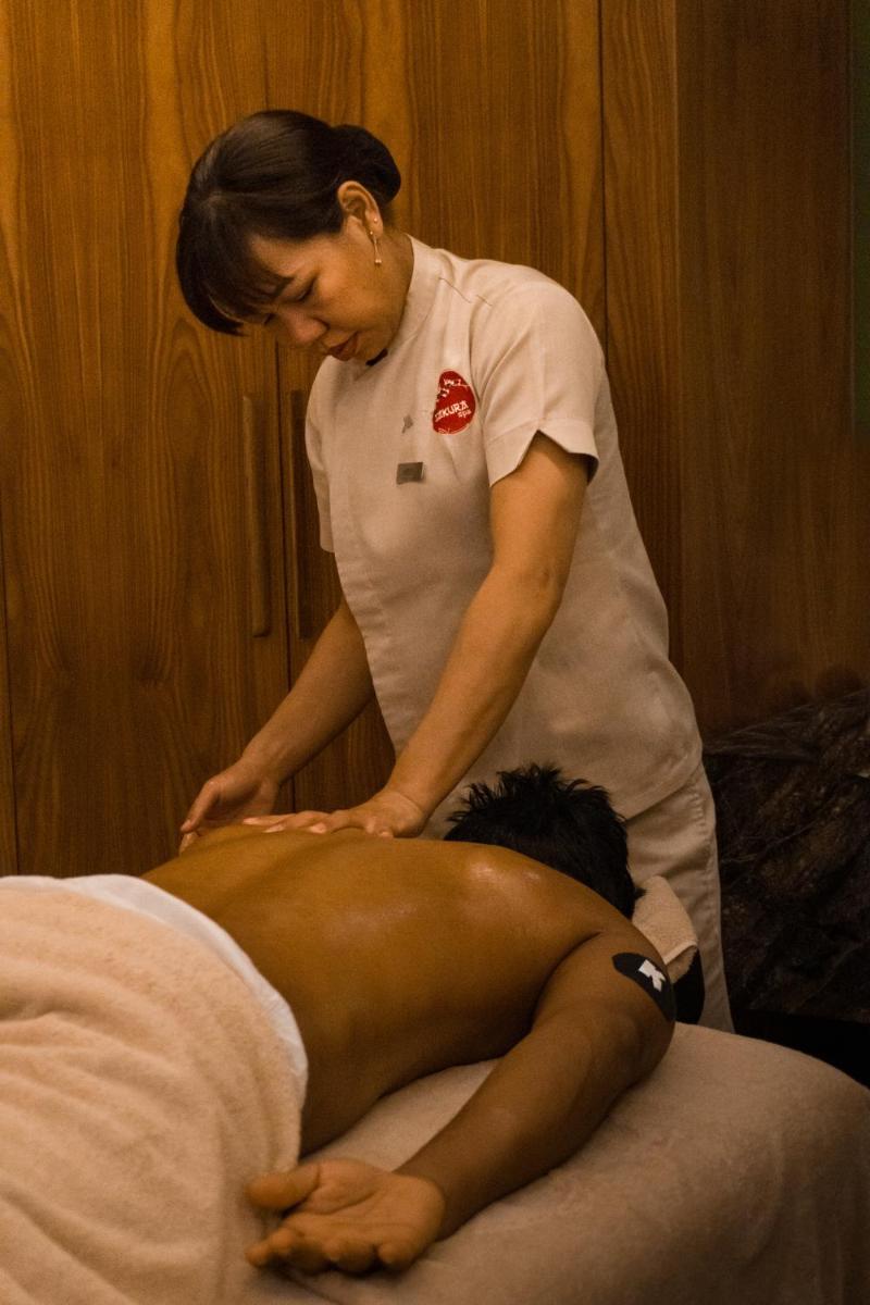 a woman is performing a massage on a persons back at Marriott Suites Pune in Pune