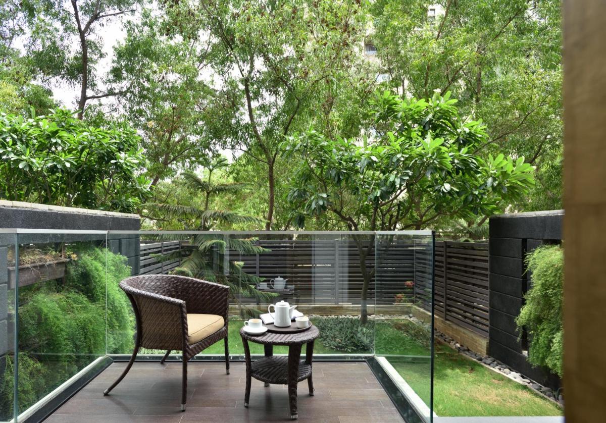 a patio with two chairs and a table on a balcony at Marriott Suites Pune in Pune