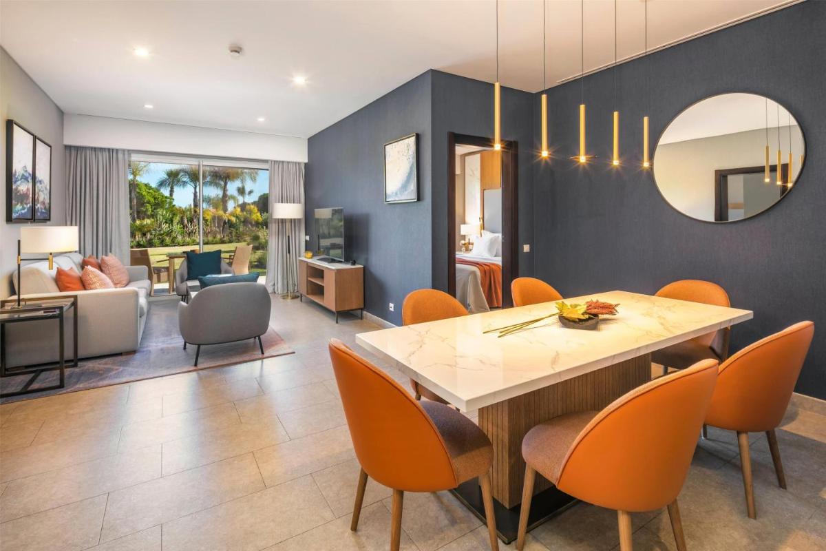 uma sala de jantar com mesa e cadeiras em Wyndham Grand Algarve na Quinta do Lago