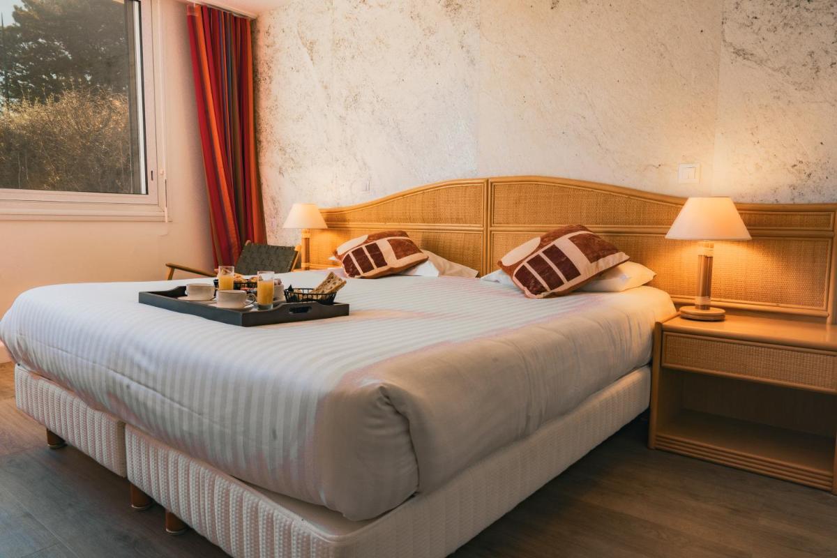 Un ou plusieurs lits dans un hébergement de l'établissement Hôtel Édenia - Spa Estime&Sens