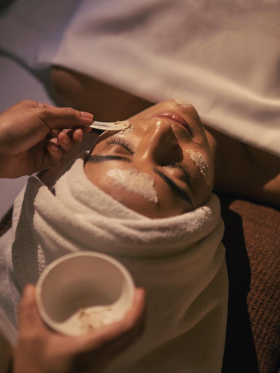 a woman getting her face covered in icing with a spoon at Four Seasons Hotel Mumbai in Mumbai