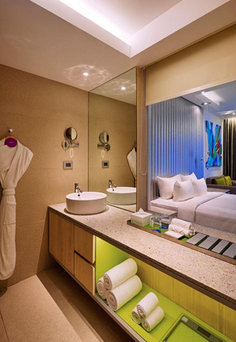 a bathroom with a sink and a large mirror at Avasa Hotel in Hyderabad