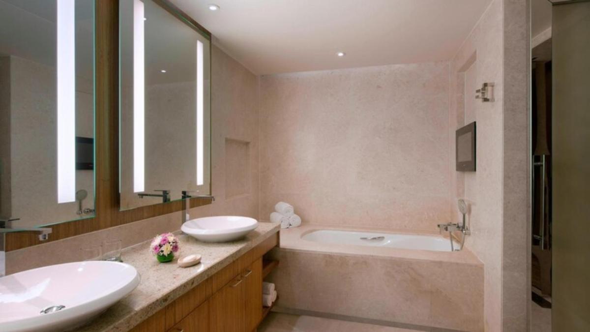 a bathroom with two sinks and a bath tub and a tubermott at Sheraton Grand Bangalore Hotel at Brigade Gateway in Bengaluru