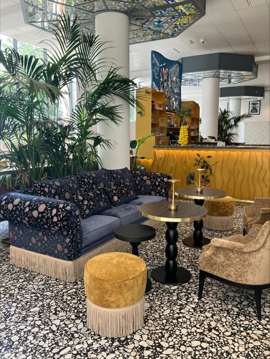 - un salon avec un canapé, des chaises et des tables dans l'établissement Dali Hôtel Montauban, à Montauban