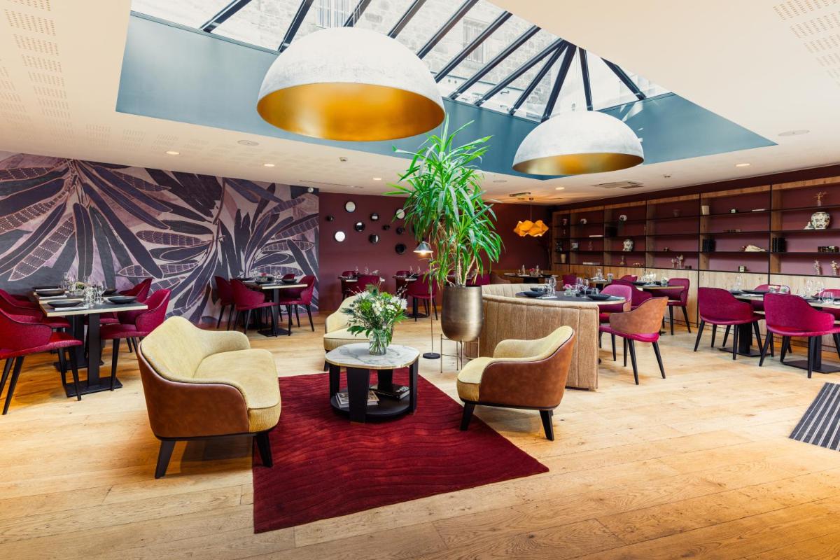 un restaurant avec des tables et des chaises et un bar dans l'établissement Edgar Hôtel & Spa - Table Gastronomique, à Saint-Brieuc