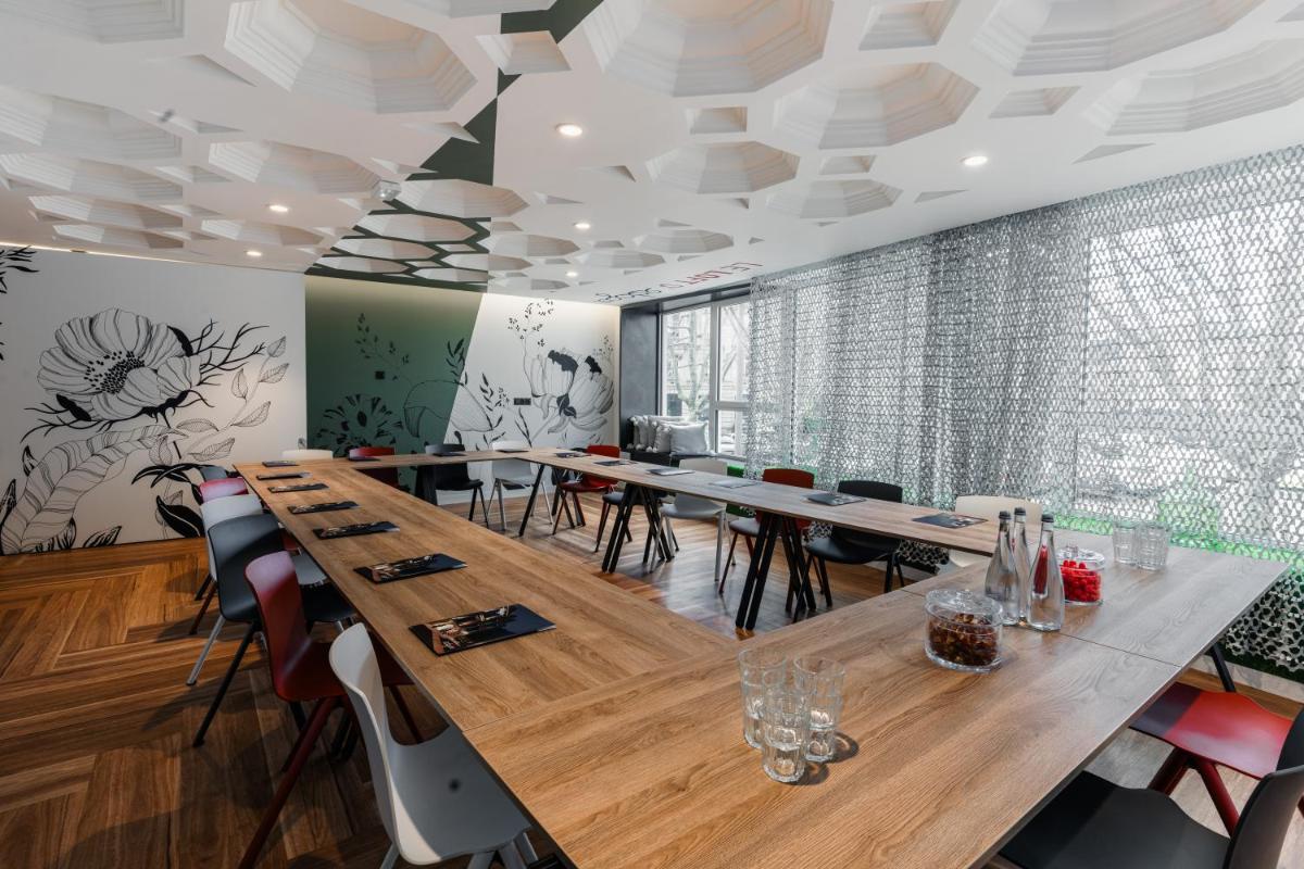 une salle de conférence avec des tables et des chaises en bois dans l'établissement Edgar Hôtel & Spa - Table Gastronomique, à Saint-Brieuc