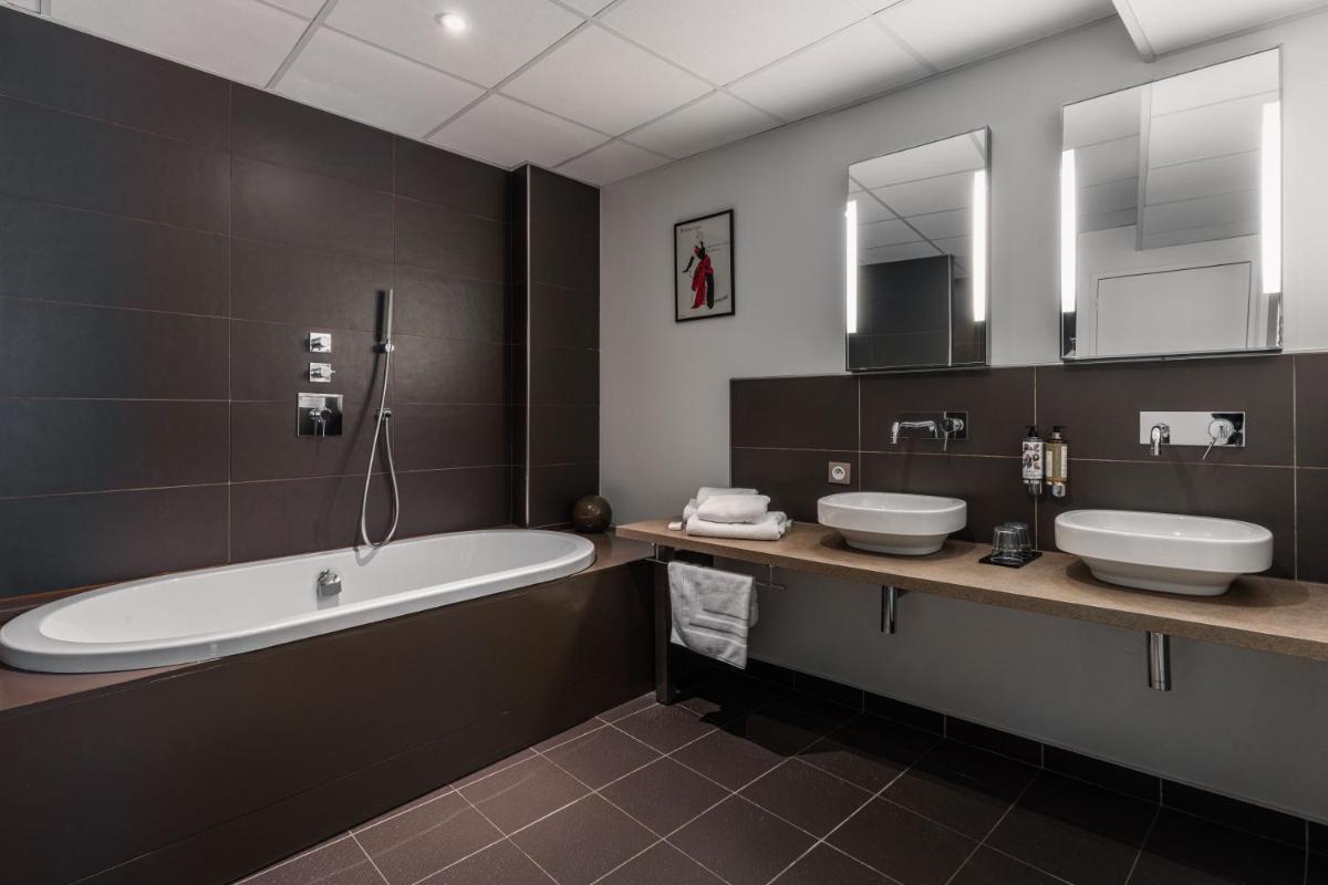 une salle de bain avec deux lavabos et une baignoire dans l'établissement Edgar Hôtel & Spa - Table Gastronomique, à Saint-Brieuc
