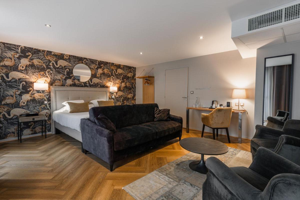 une chambre d'hôtel avec un lit et un salon dans l'établissement Edgar Hôtel & Spa - Table Gastronomique, à Saint-Brieuc