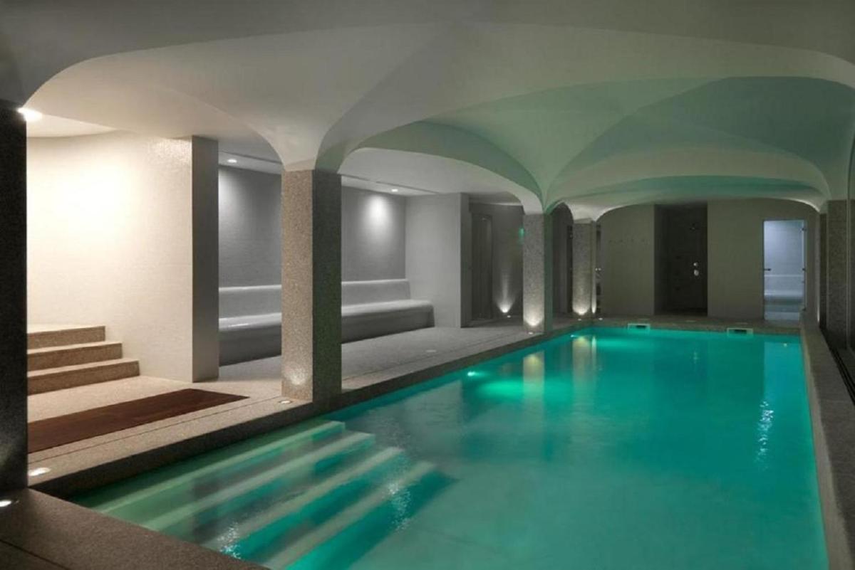 uma piscina com água azul em um prédio em Abrigo da Montanha Hotel Rural em Sabugueiro uma piscina com água azul em um prédio em Abrigo da Montanha Hotel Rural em Sabugueiro