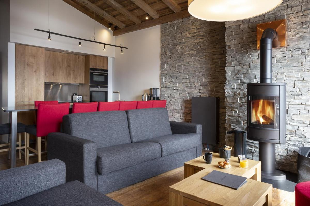 un salon avec un canapé et une cheminée dans l'établissement Hôtel Alparena & Spa - 4 étoiles, à La Rosière
