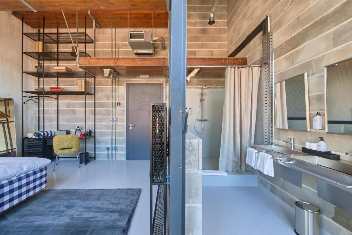um quarto com uma cama, um lavatório e uma casa de banho em Moagem Industrial Lodge em Viana do Alentejo