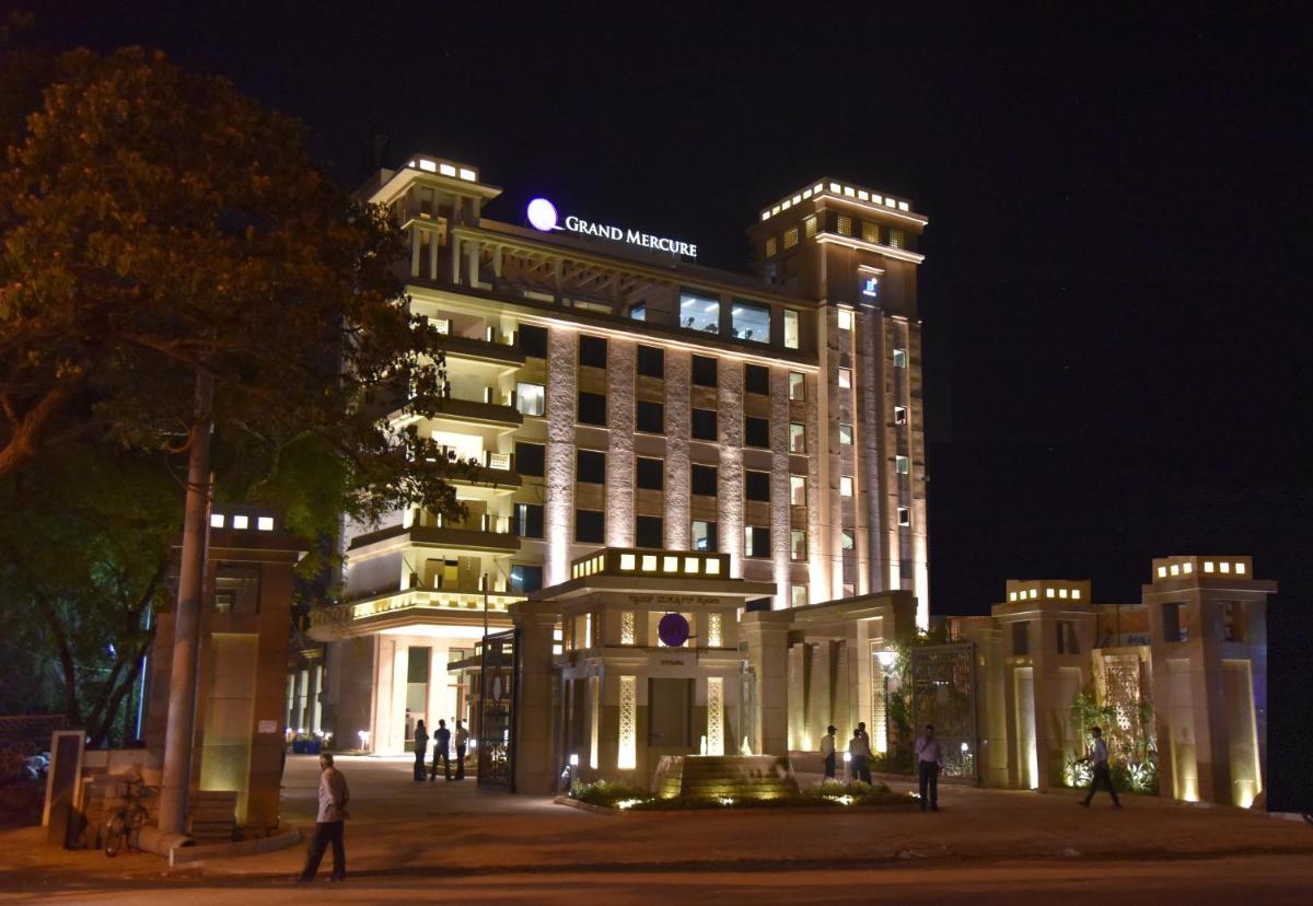 a large building with people standing in front of it at night at Grand Mercure Mysore - An Accor Brand in Mysore