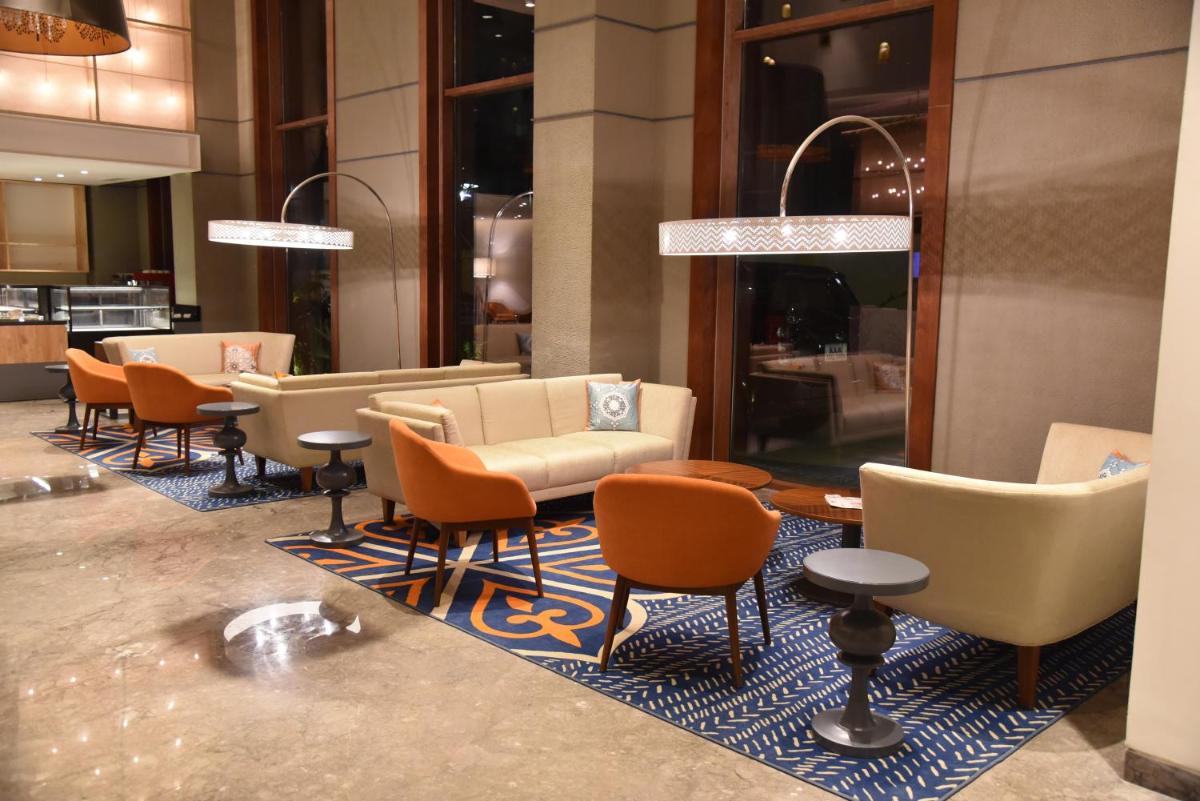 a lobby with a row of chairs and tables at Grand Mercure Mysore - An Accor Brand in Mysore