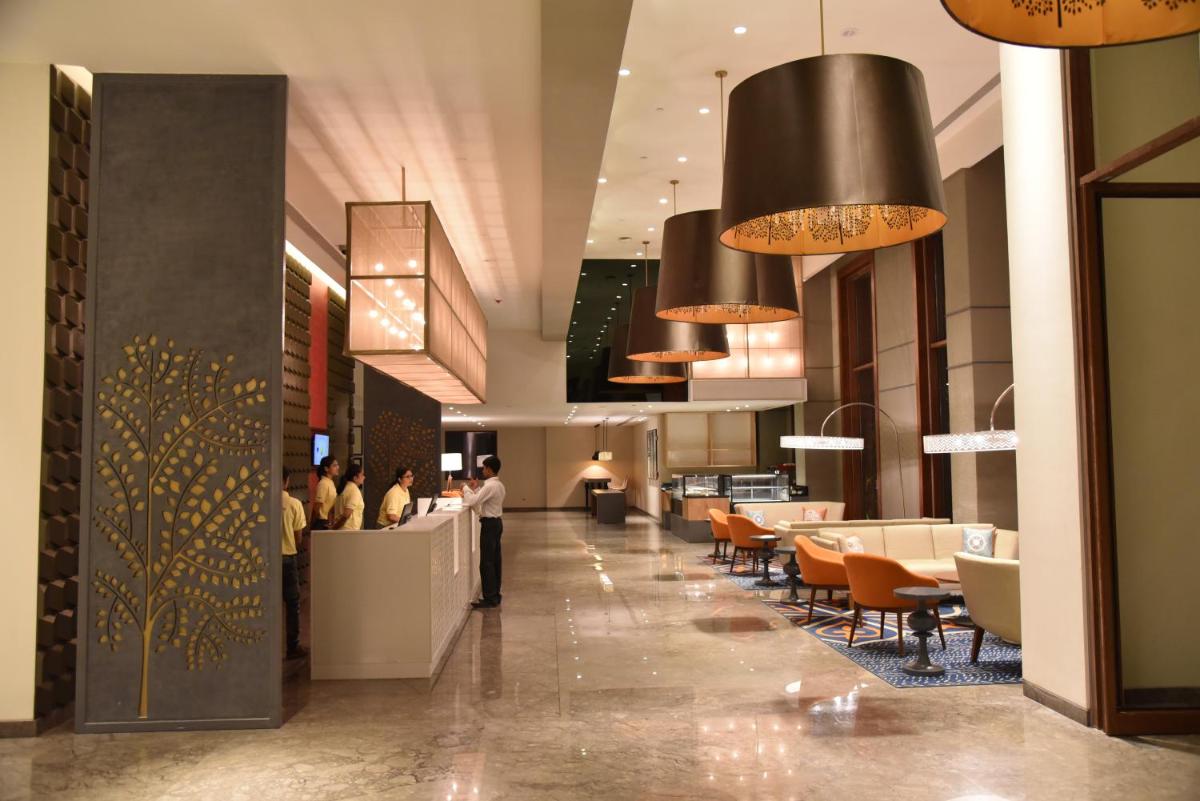 a lobby of a hotel with people standing at a counter at Grand Mercure Mysore - An Accor Brand in Mysore