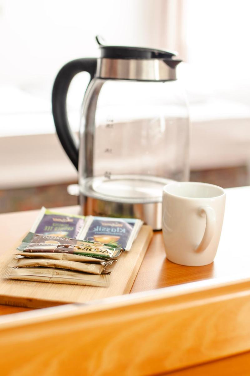 eine Kaffeekanne und eine Tasse auf dem Tisch in der Unterkunft Villa ENTO HotelWestEnd in Frankfurt am Main