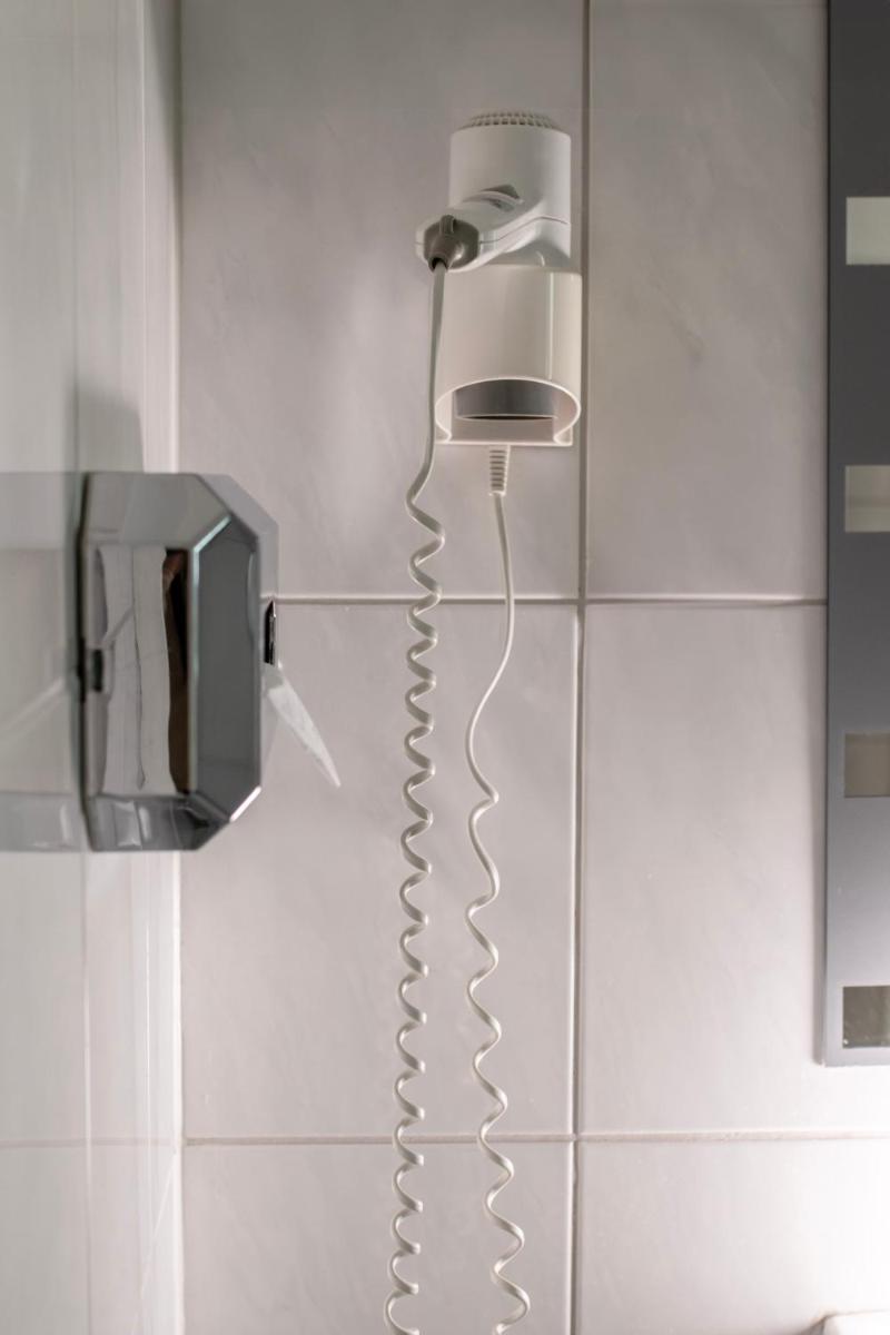 ein Telefon, das an einer Wand im Bad hängt in der Unterkunft Villa ENTO HotelWestEnd in Frankfurt am Main + 37 Fotos