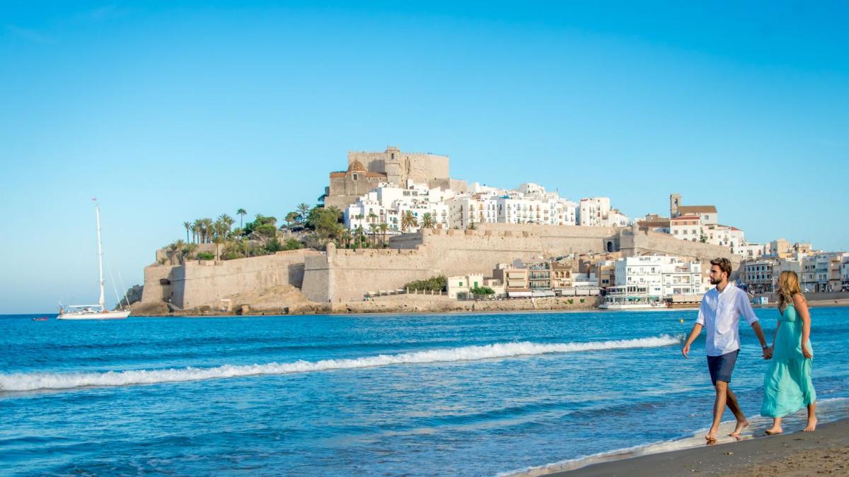 un hombre y una mujer caminando por la playa en RH Don Carlos & Spa, en Peñíscola 29 fotos más