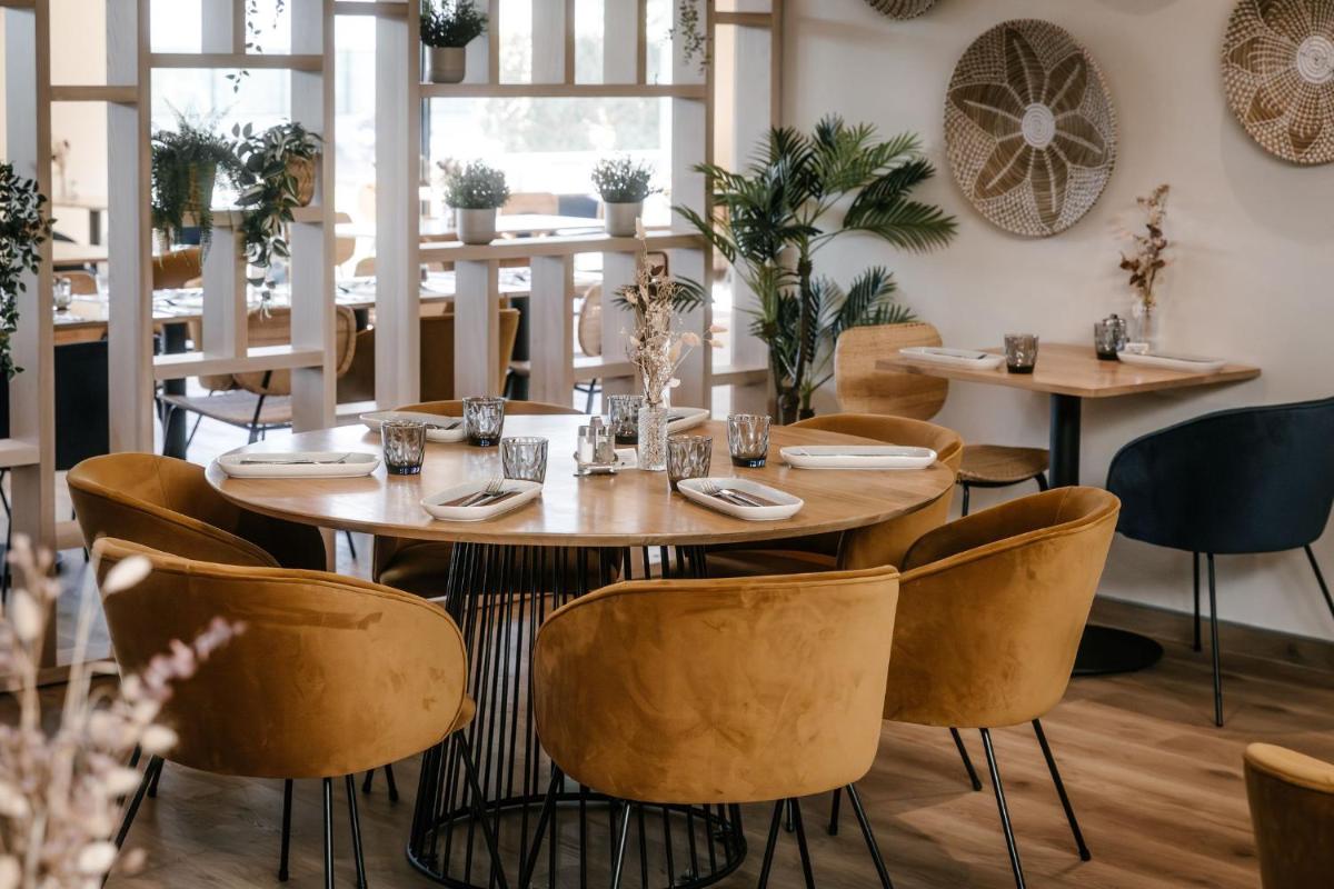 une salle à manger avec des tables et des chaises dans un restaurant dans l'établissement 7Hotel&Spa, à Illkirch-Graffenstaden