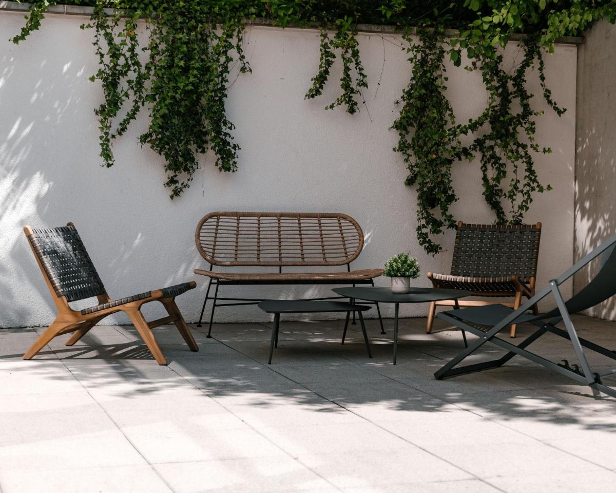 deux chaises et un banc et une table contre un mur dans l'établissement 7Hotel&Spa, à Illkirch-Graffenstaden 93 autres photos
