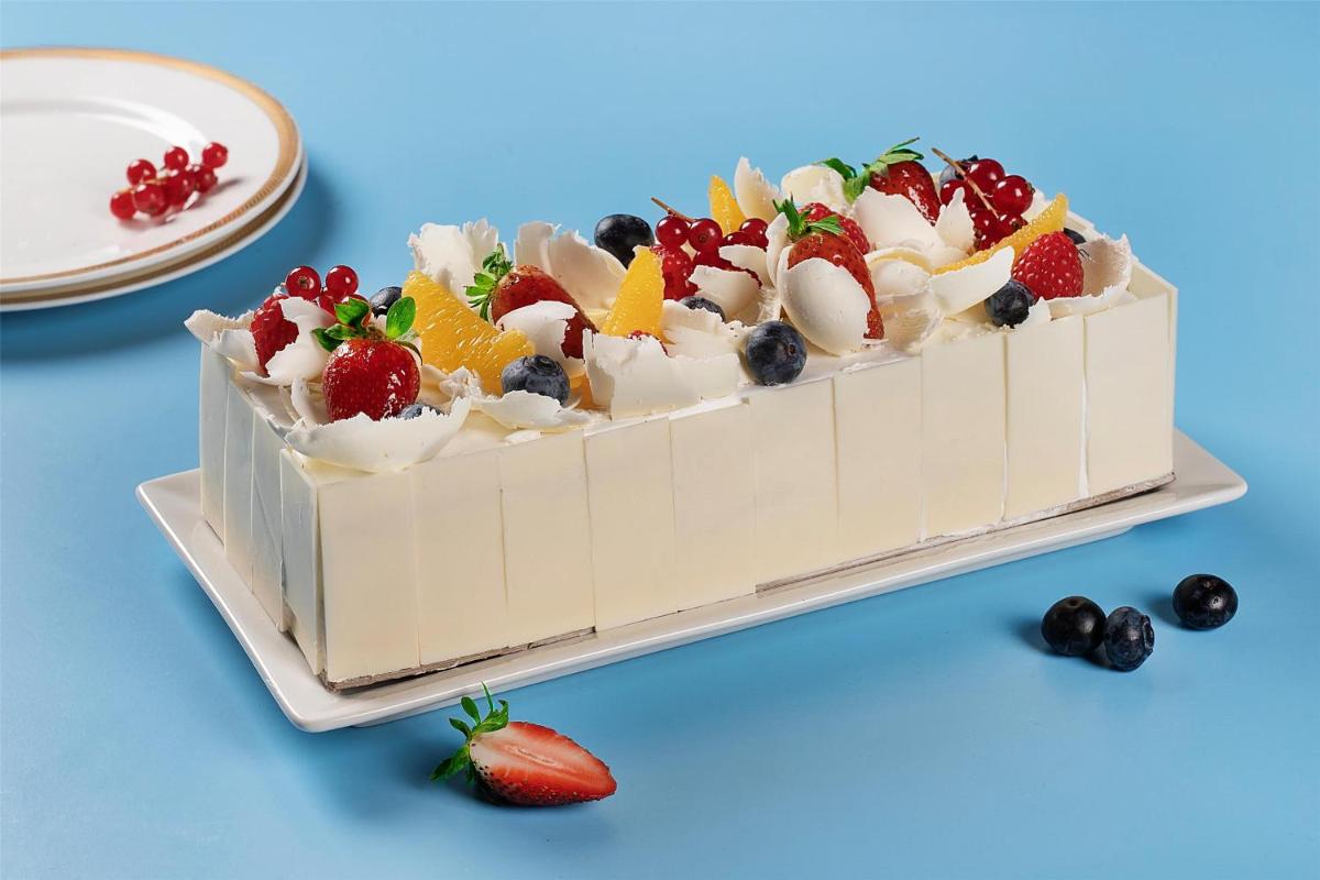 a cake with fruit on a plate with a strawberry at Radisson Blu Hotel New Delhi Dwarka in New Delhi a cake with fruit on a plate with a strawberry at Radisson Blu Hotel New Delhi Dwarka in New Delhi