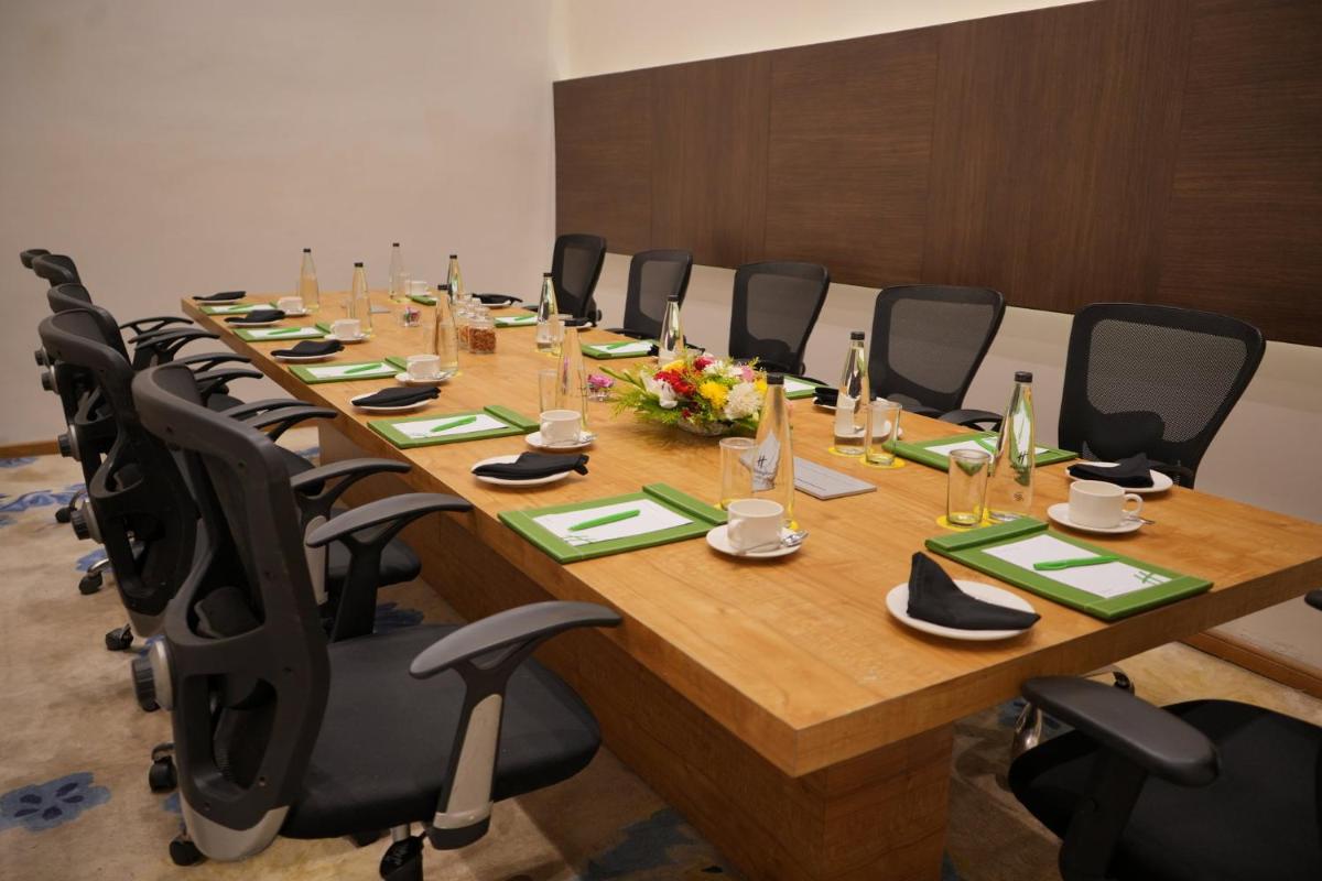 a conference room with a long wooden table and chairs at Holiday Inn Kolkata Airport by IHG in Kolkata
