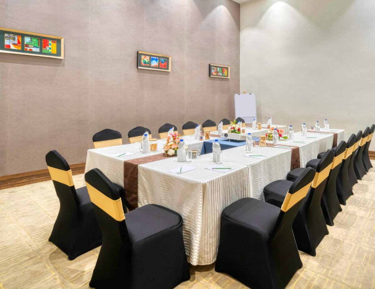 a conference room with a long table and chairs at Holiday Inn Kolkata Airport by IHG in Kolkata