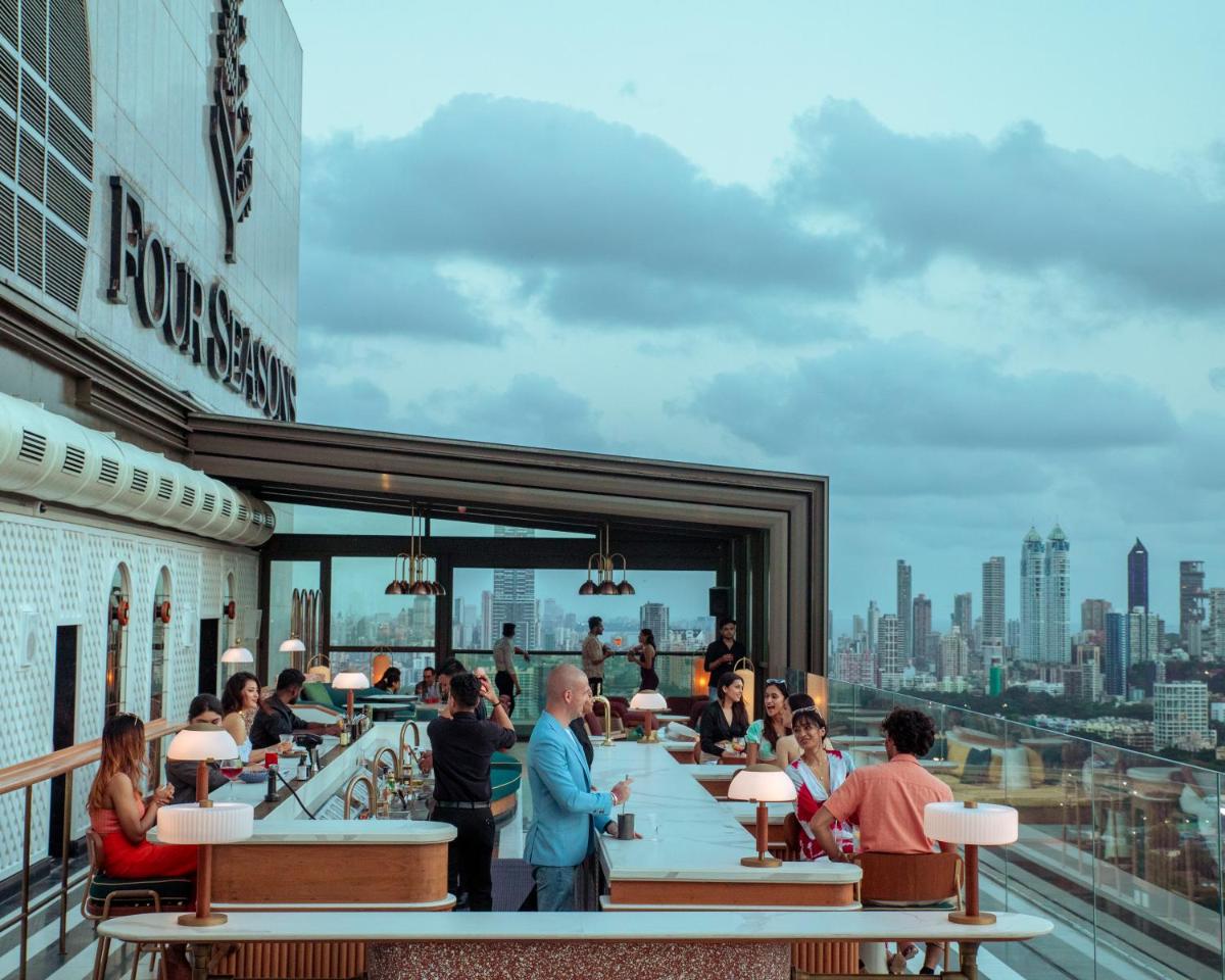people sitting at a bar on the roof of a building at Four Seasons Hotel Mumbai in Mumbai