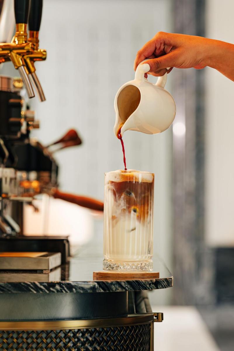 a person is pouring liquid into a drink at Four Seasons Hotel Mumbai in Mumbai