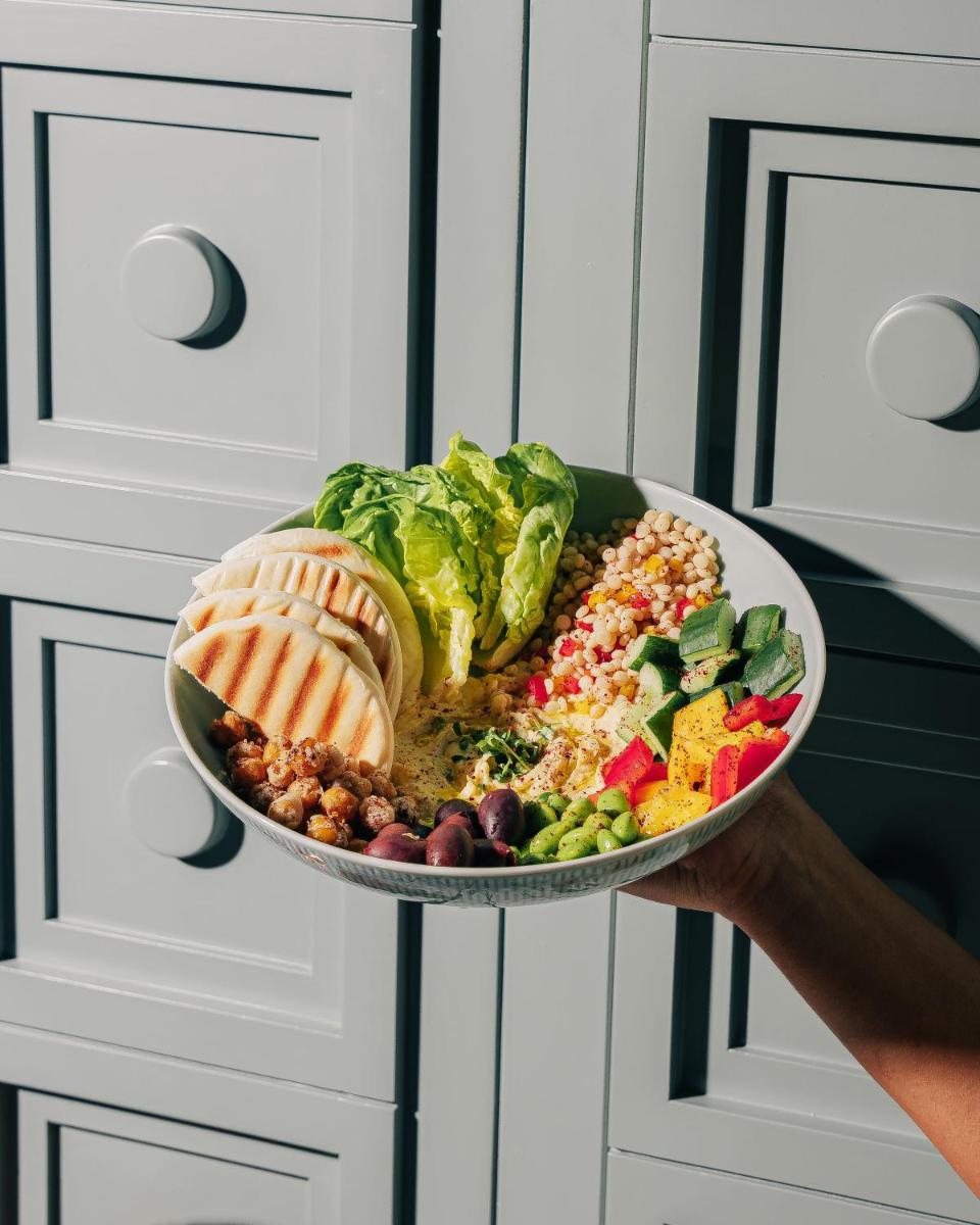 a person holding a plate with food on it at Four Seasons Hotel Mumbai in Mumbai