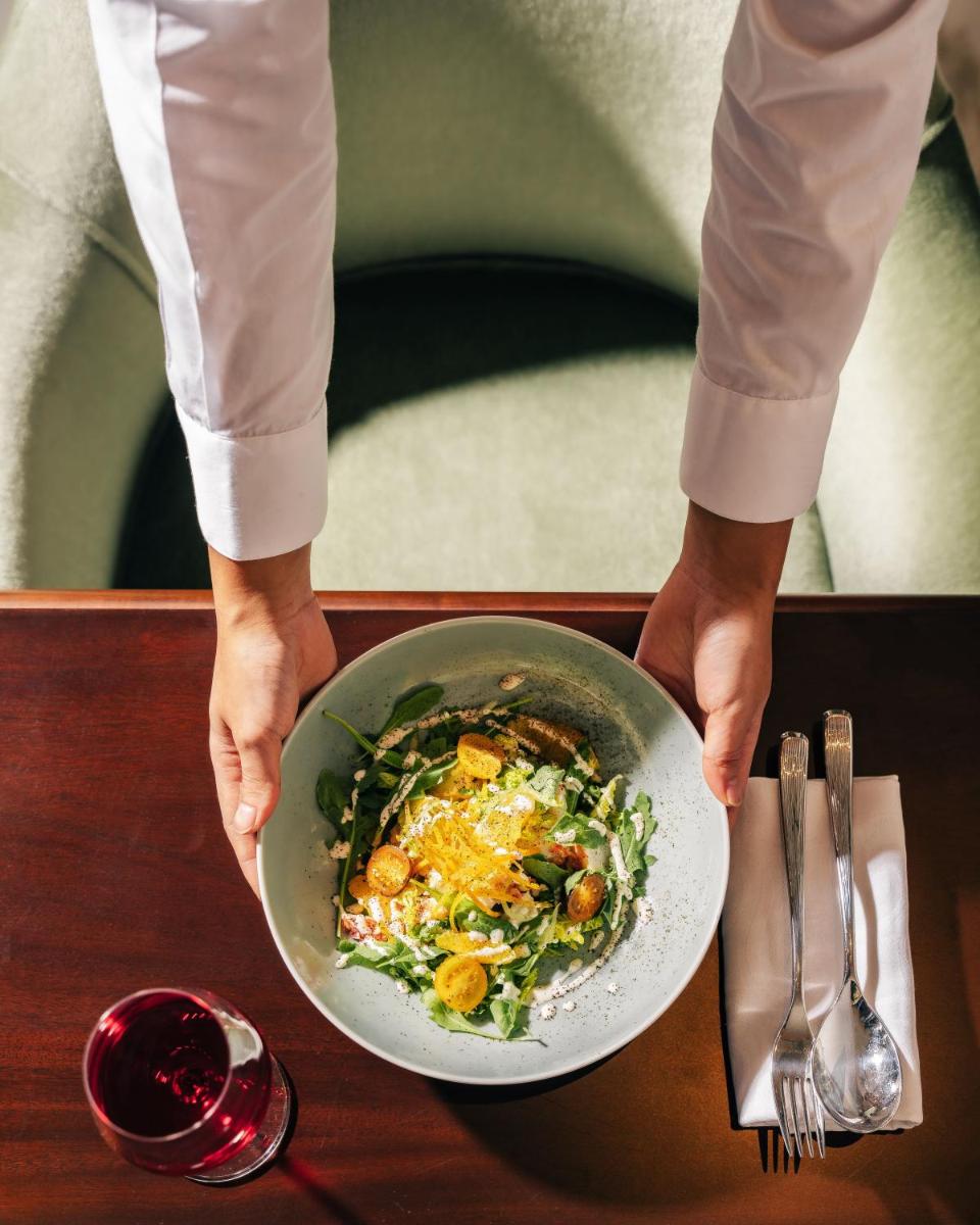 a person holding a bowl of food on a table at Four Seasons Hotel Mumbai in Mumbai