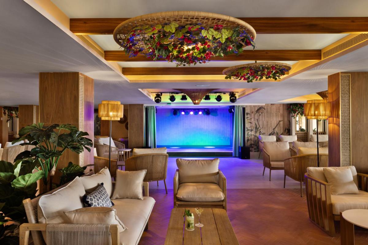 un vestíbulo de un hotel con sofás y un bar en Hotel Riu Palace La Mola, en Playa de Migjorn