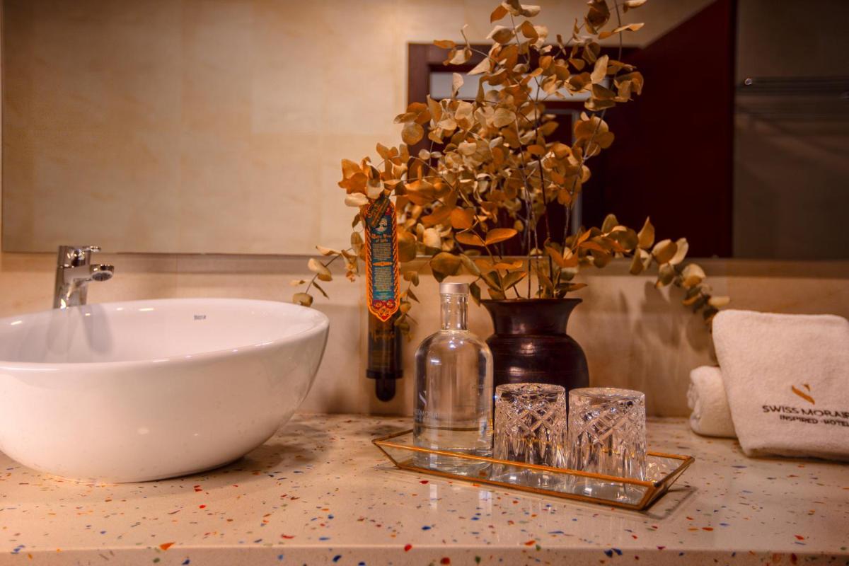 Un lavabo y vasos sobre un mostrador en un baño. en SWISS MORAIRA HOTEL & SPA - Adults only, en Moraira