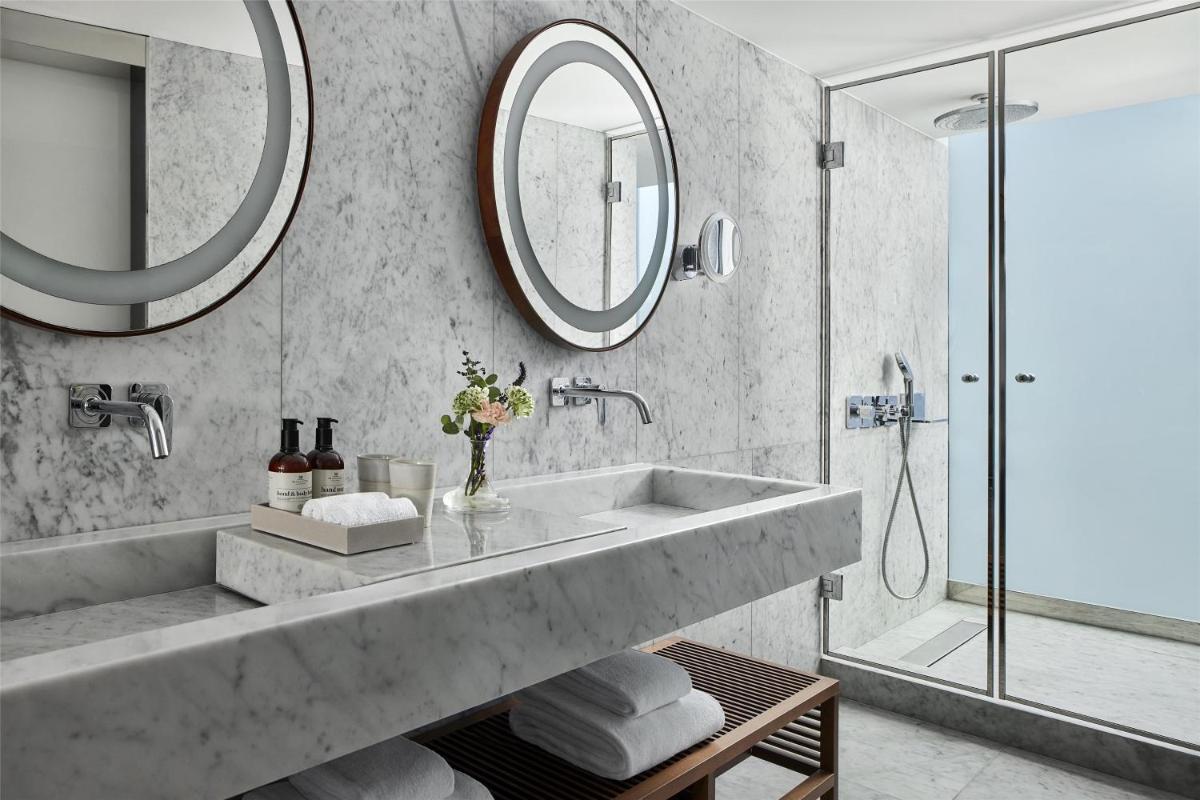 Un baño con un lavabo grande y un espejo. en NH Collection Ibiza, en Ibiza