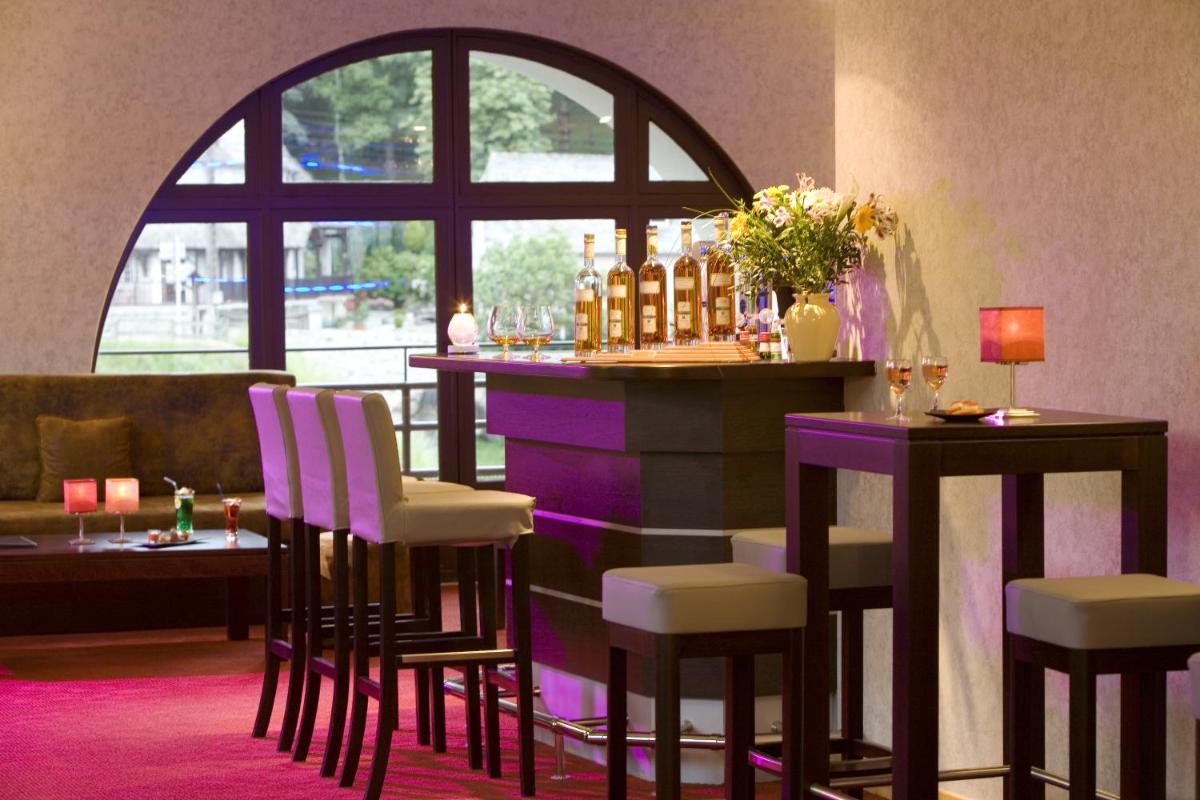 un bar dans une pièce avec des chaises et une table dans l'établissement Hôtel La Rivière, à Entraygues-sur-Truyère