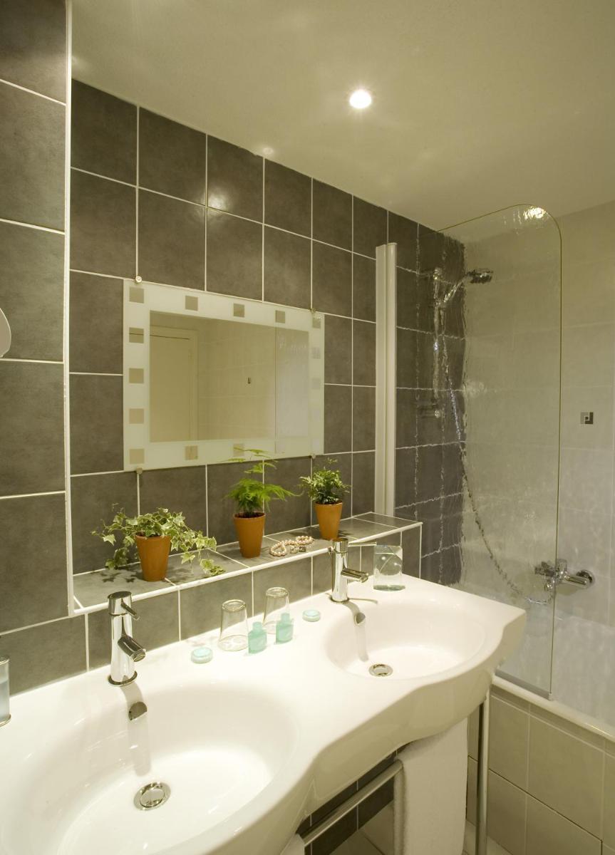 une salle de bains avec lavabo, miroir et douche dans l'établissement Hôtel La Rivière, à Entraygues-sur-Truyère