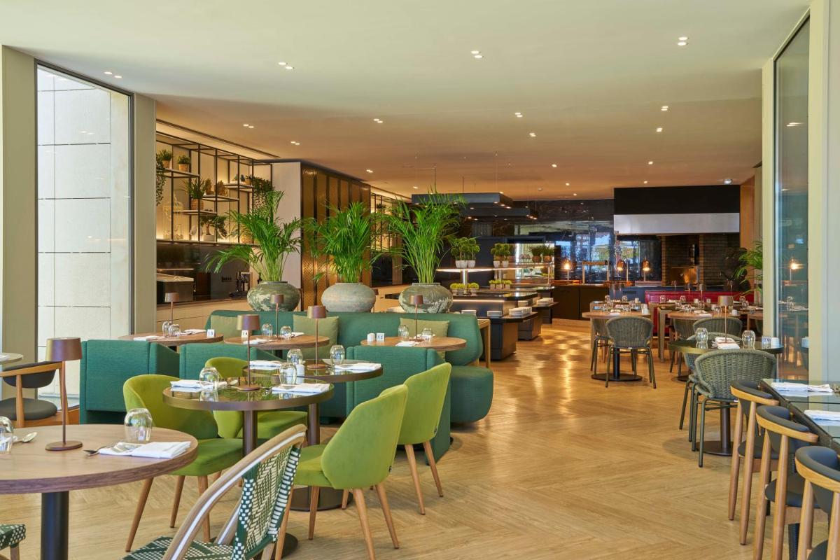 uma sala de jantar com mesas e cadeiras e um restaurante em Golden Residence Hotel no Funchal