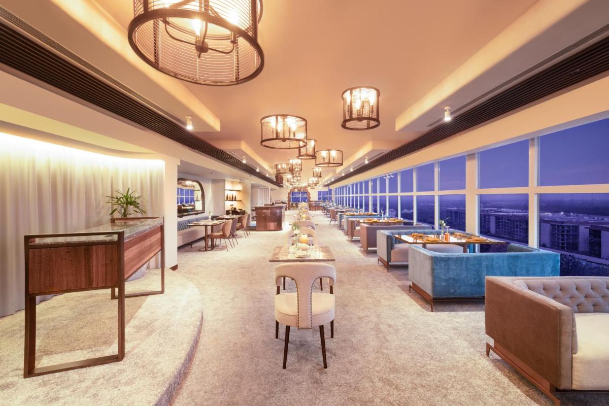 a hotel lobby with couches and tables and windows at Le Meridien New Delhi in New Delhi a hotel lobby with couches and tables and windows at Le Meridien New Delhi in New Delhi