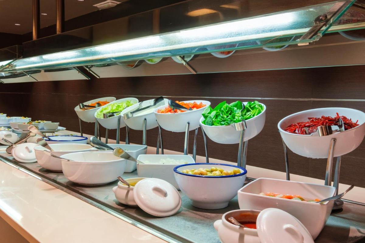 una línea de buffet con tazones de comida en una mesa en Cabot Cap de Mar Spa, en Cala Bona